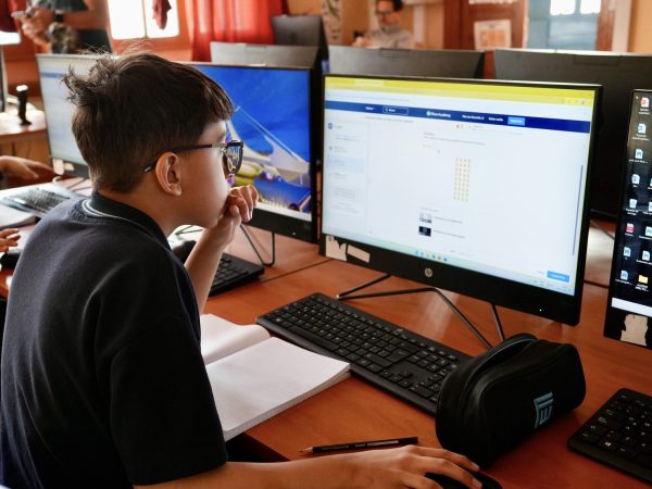 Estudiantes trabajando con computadores en la sala de computación