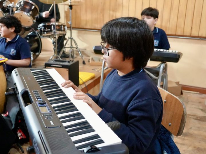 Estudiante tocando el teclado en la sala de música